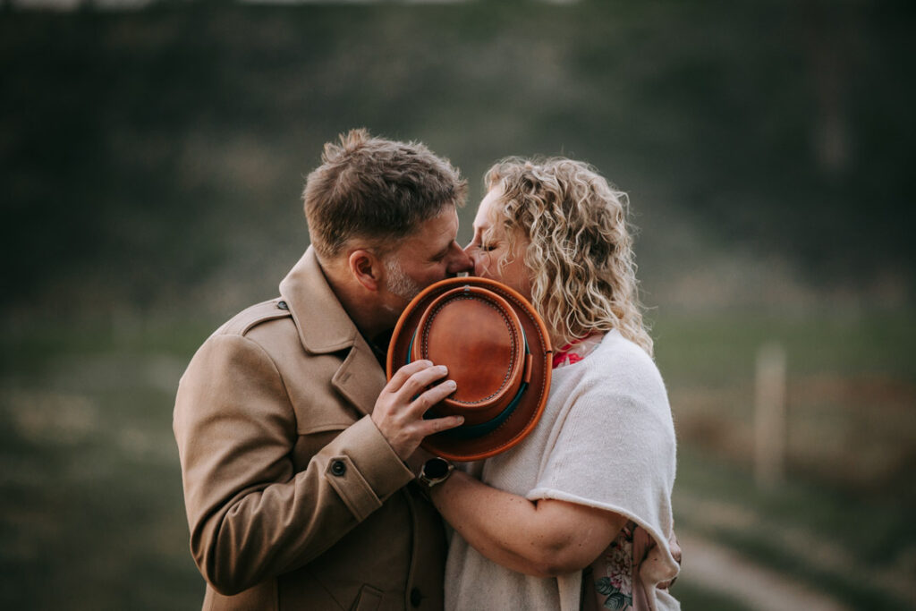 Par som kysser bag en hat