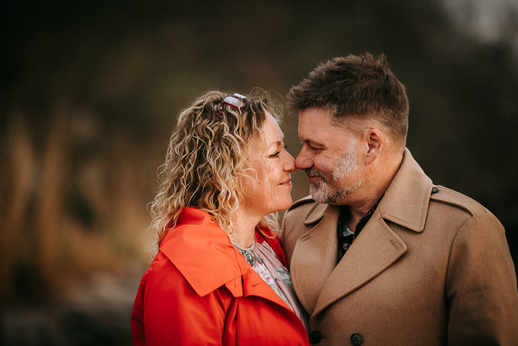 Udendørs parfotografering – par i varmt kram i den gyldne time.