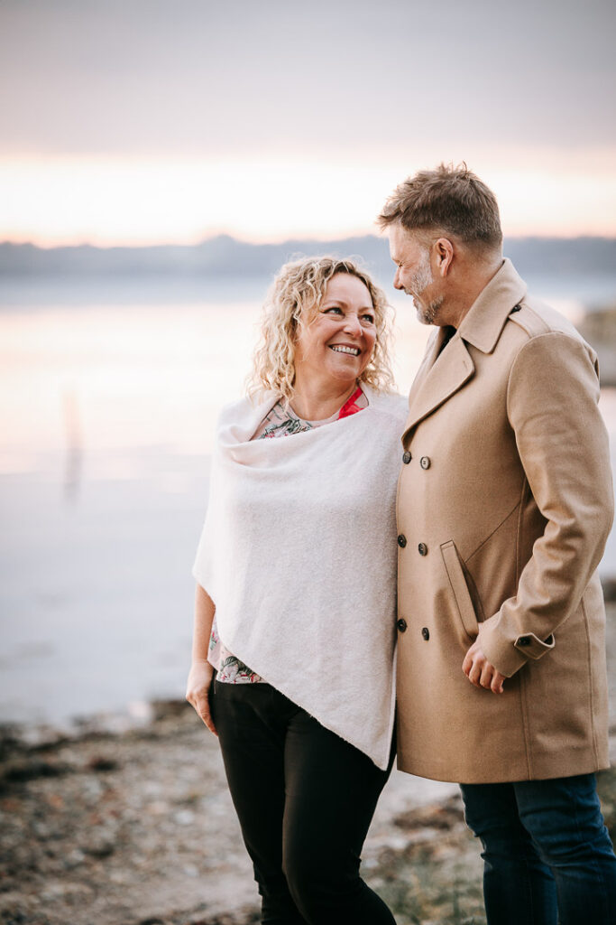 Parfotografering ved Hindsgavl Slot – par står tæt med vandet bag dem.