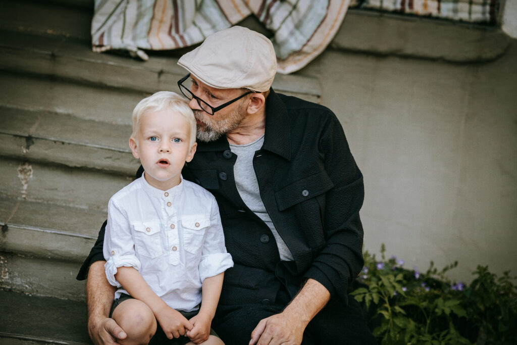 Bedstefar kysser sit barnebarn på hovedet under familiefotografering