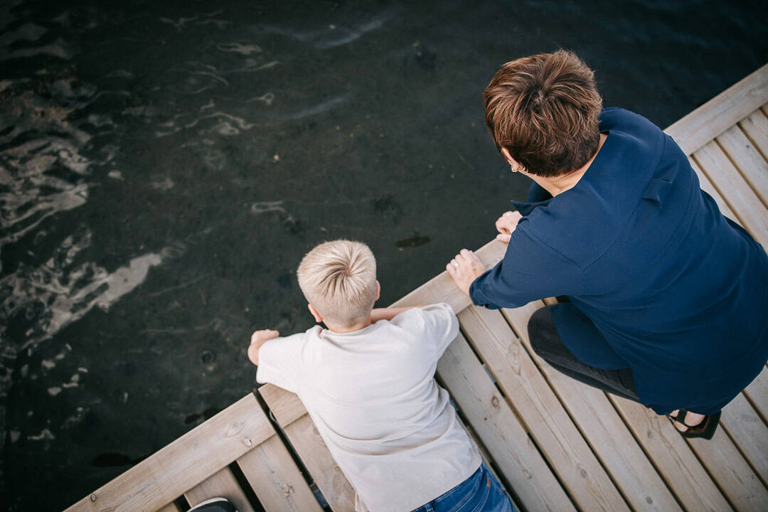 Mor og søn leger ved vandet fra badebro – familiefotograf Holstebro fanger ægte øjeblikke.