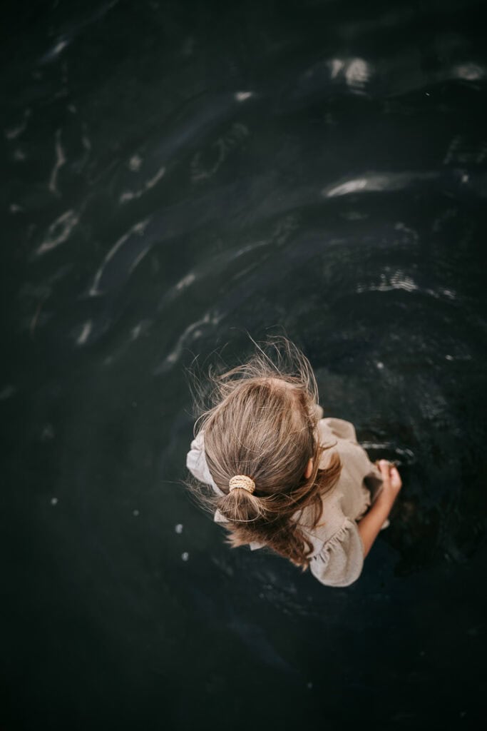 Barn svømmer i vandet set fra oven – autentisk børnefotografering ved stranden i Struer.