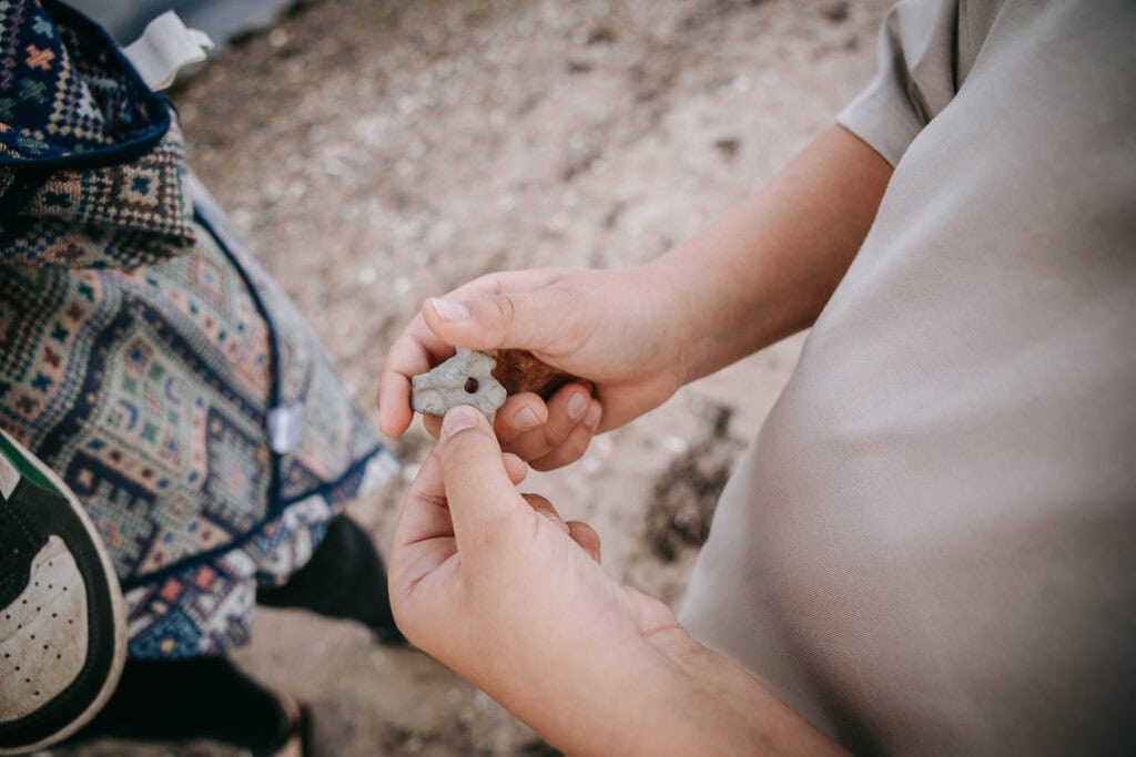 Barn viser musling fundet i sandet – naturligt familiefoto fra Struer.