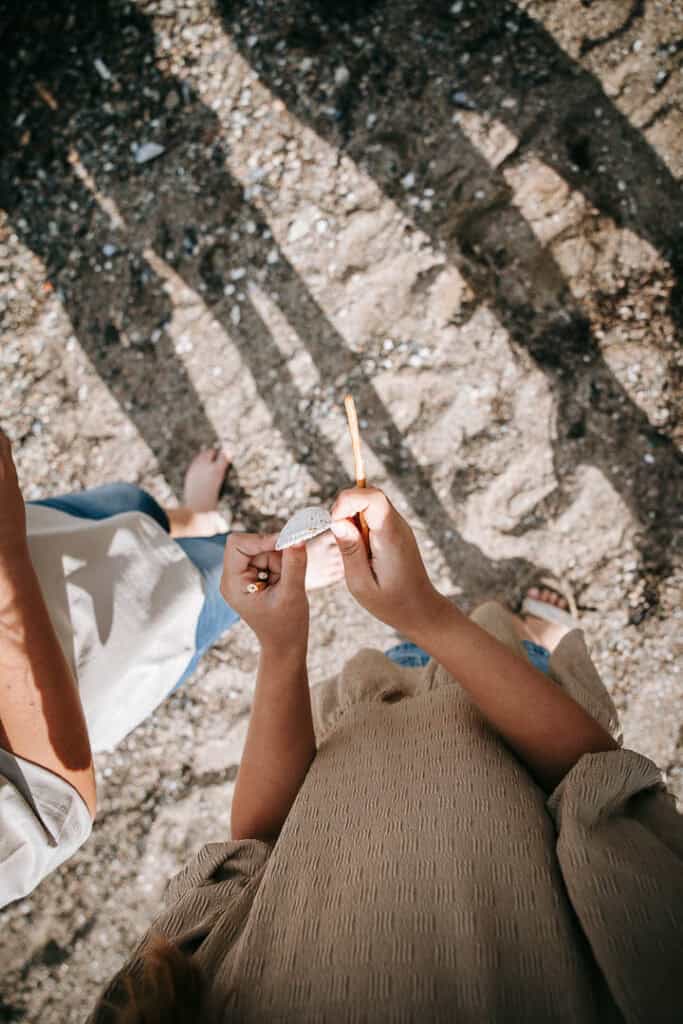 Børn, der samler skaller på stranden i solskin – naturlig børnefotografering i Lemvig.