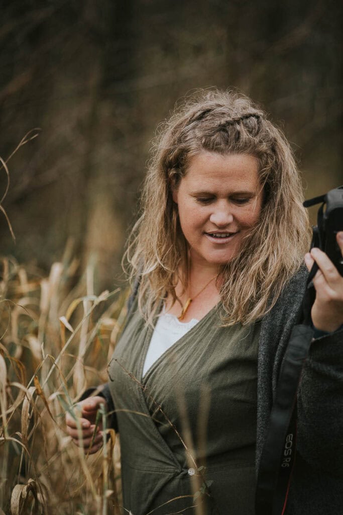 Portræt med kamera i hånden, blødt fokus og varmt udtryk. Fotograf i Struer.