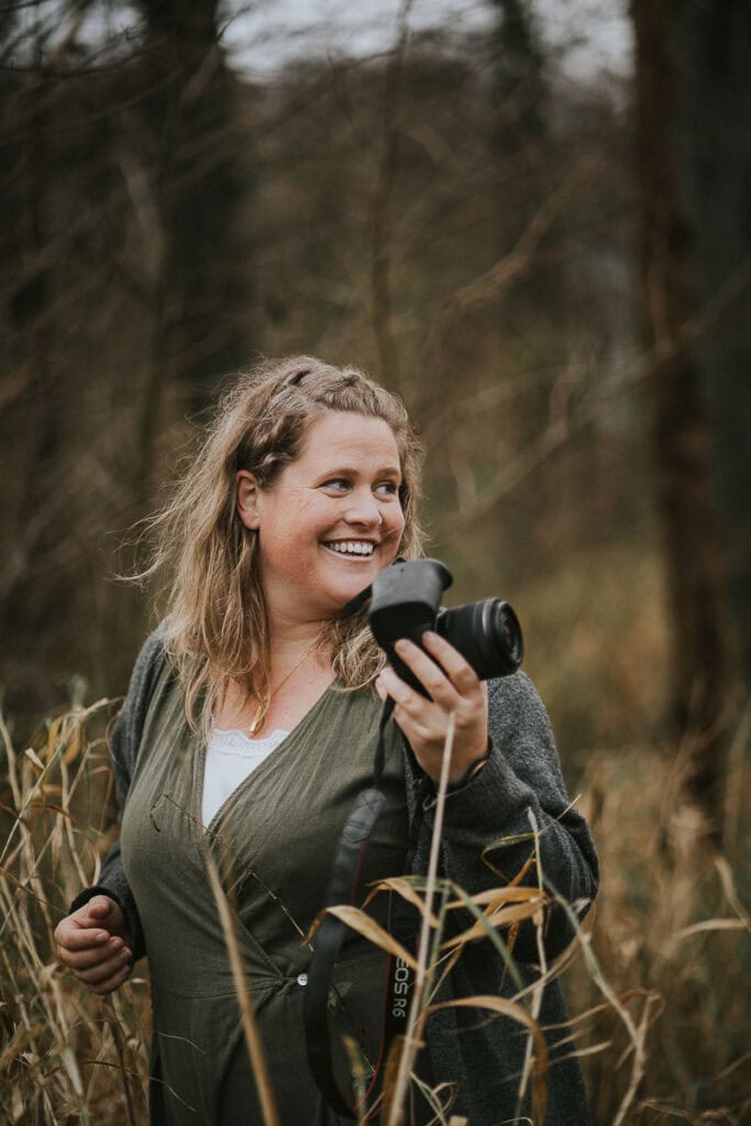 Zoey Elinor med kamera, let smil og afslappet energi. Brandingbilleder til solovirksomheder i Vestjylland.