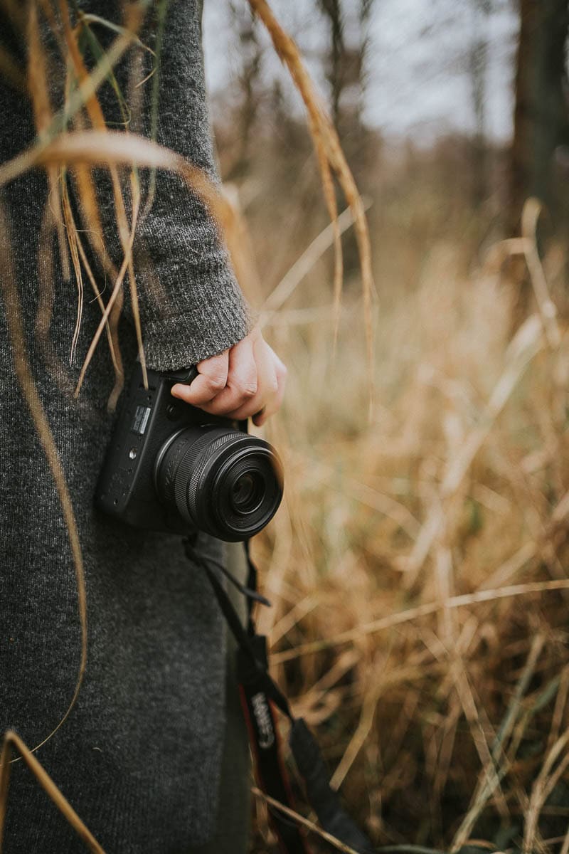 Kamera og græsstrå i forgrunden, dokumentarisk udtryk. Billeder til hjemmeside med naturlig varme