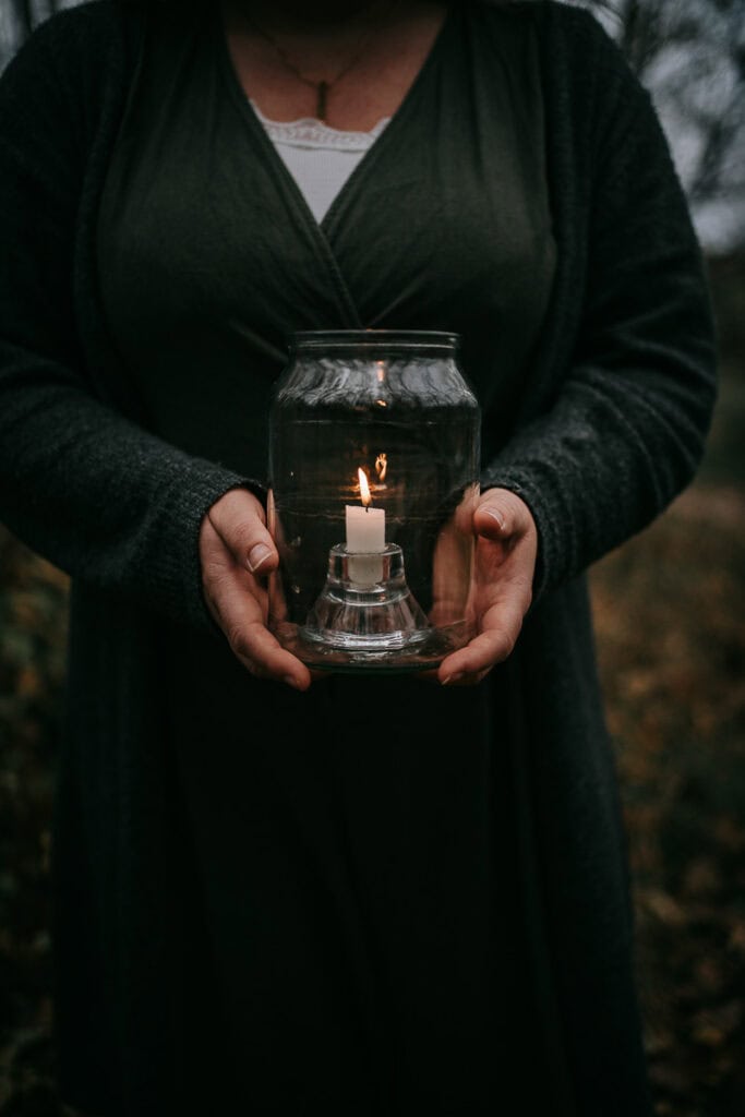 Detaljebillede af hænder omkring lys i glas. Roligt og sanseligt udtryk. Billeder til hjemmeside med nærvær.