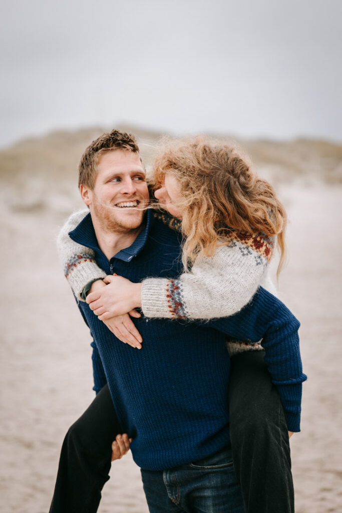 Kvinde på mands ryg, smil og grin – naturlige parportrætter Lemvig.