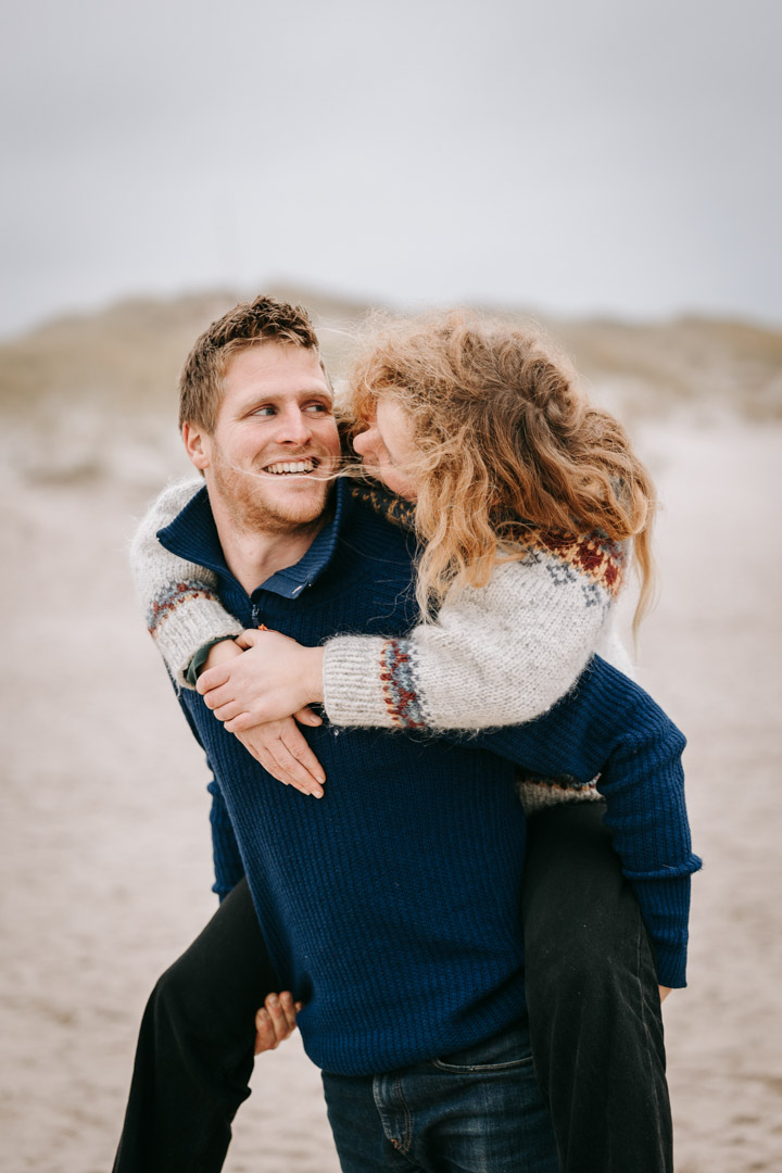 Kvinde på mands ryg, smil og grin – naturlige parportrætter Lemvig.