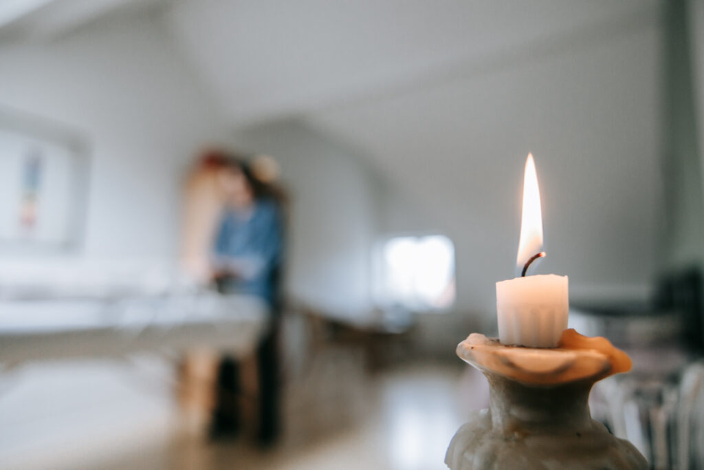 Tændt stearinlys i behandlingsrum skaber en rolig atmosfære.