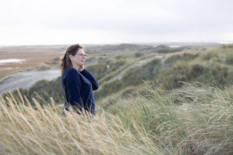 Terapeut stående med udsigt over landskabet på Rømø.