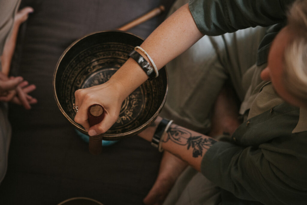 Nærbillede af hænder, der holder en syngeskål – billeder af energi i shamanistisk praksis.