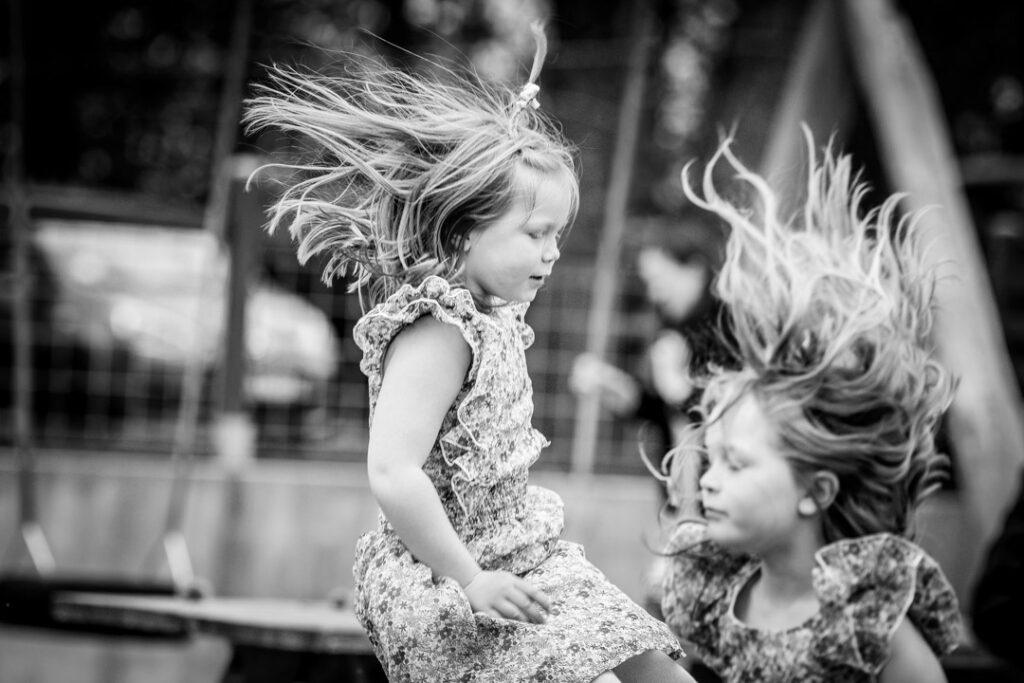 Sort-hvid stemningsbillede af børn der leger og griner under konfirmationsfesten.