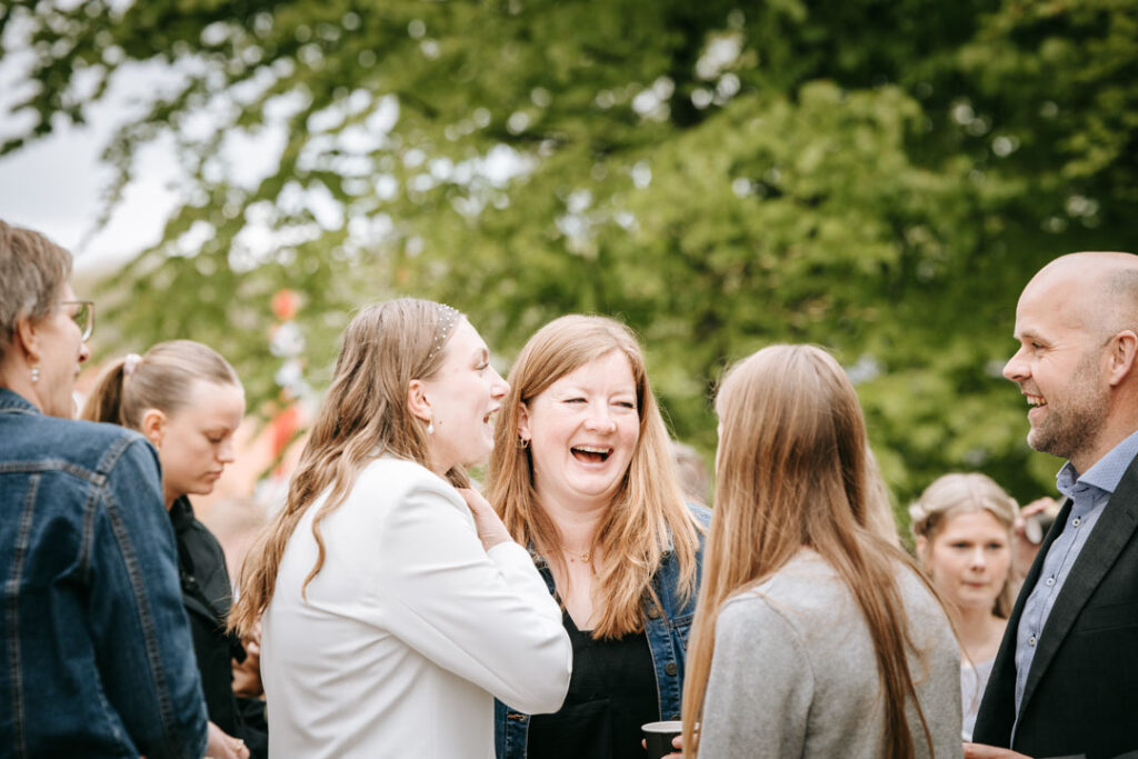 Veninder samles omkring konfirmanden og taler sammen i afslappet stemning på dagen.