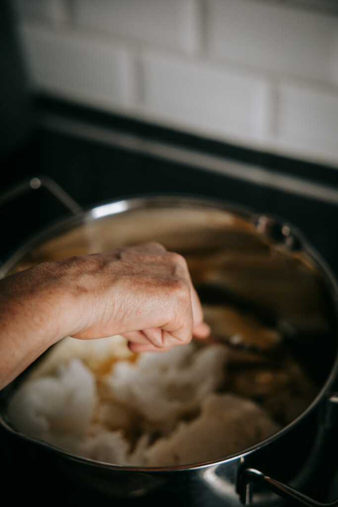 Nærbillede til hjemmeside af hånd i gryde med rå masse